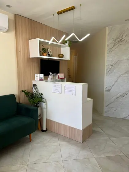 Recepção do consultório com plantas e sofá verde